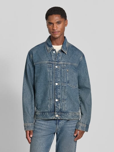 Männermodel trägt Regular Fit Jeansjacke aus Baumwoll-Lyocell-Mix Modell 'AASHTON' von ARMEDANGELS, blaue Denim-Textur, Ganzkörperansicht von vorne. Herren Jeansjacke von ARMEDANGELS.