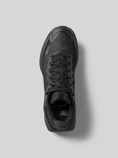 Produktfoto, Sneaker mit Schnürverschluss von Salomon in Schwarz, abgerundete Form, Label-Print, strukturierte Sohle, Draufsicht.