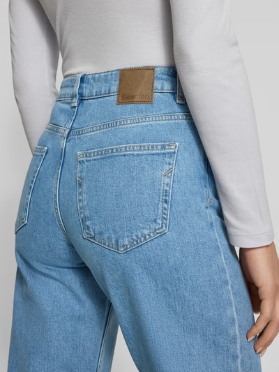 Vrouwenmodel draagt Wide Leg Jeans uit katoenmix model 'WIDE BEA-KORI' van Selected Femme, denim look, 5-pocket, detailopname rug.