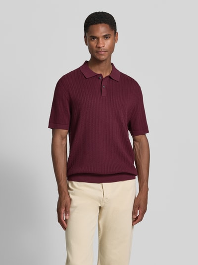Männermodel trägt Regular Fit poloshirt met structuurpatroon van Christian Berg Men in bordeaux met polokraag en korte knoopsluiting, ruglengte bij maat M 72 cm, mouwlengte bij maat M 25 cm, ganzekörperansicht van voren.