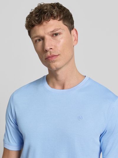Männermodel trägt T-Shirt mit Rundhalsausschnitt von bugatti in Hellblau, Baumwoll-Mix, Label-Detail, Regular Fit, Nahaufnahme Oberkörper.