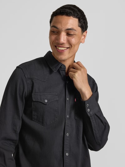 Mężczyzna nosi koszulę jeansową Regular Fit Jeanshemd aus reiner Baumwolle model 'BARSTOW WESTERN STANDARD' von Levi's®, z przodu, zbliżenie na górną część.