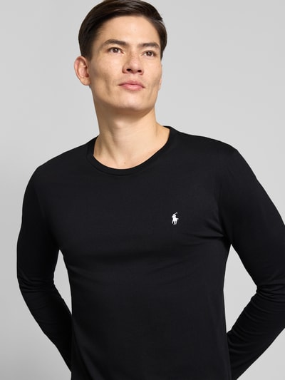 Männermodel trägt Longsleeve aus Baumwolle mit Label-Stitching von Polo Ralph Lauren in Schwarz, Rundhalsausschnitt, Nahaufnahme Oberkörper.