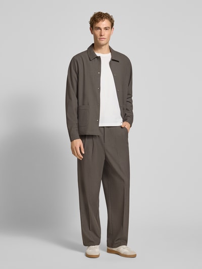 Männermodel trägt Straight Fit Hose mit Viskose-Anteil Modell 'Grant' von Casual Friday in Braun, Teilelastikbund, Ganzkörperansicht von vorne.