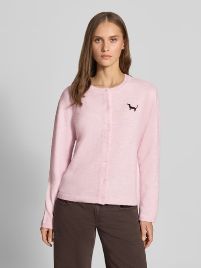 Frauenmodel trägt Regular Fit Strickjacke mit Rundhalsausschnitt Modell 'EVIA' von ONLY in Rosa, glatte Struktur, Damen Strickjacke, Nahaufnahme Oberkörper.