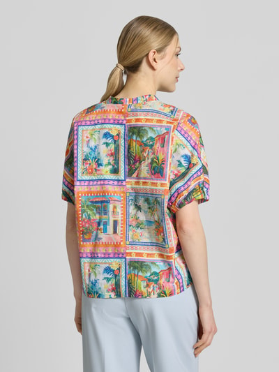 Frauenmodel trägt Relaxed Fit Bluse mit Rundhalsausschnitt von Emily Van den Bergh aus reiner Baumwolle im farbenfrohen Allover-Look, Ganzkörperansicht Rückansicht.
