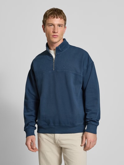 Männermodel trägt dunkelblaues Sweatshirt mit Reißverschluss Modell 'MARINA QUARTER ZIP' von Levi's®, Ganzkörperansicht von vorne. Reine Baumwolle, Regular Fit, Stehkragen, sichtbare Nähte, glatte Textur.