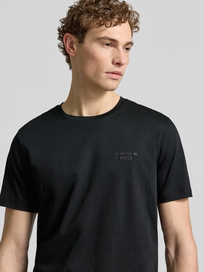 Männermodel trägt Regular Fit T-Shirt aus reiner Baumwolle Modell 'PS Spirit 70 Grx' von BOSS Green X PORSCHE, unifarben, Nahaufnahme Oberkörper.