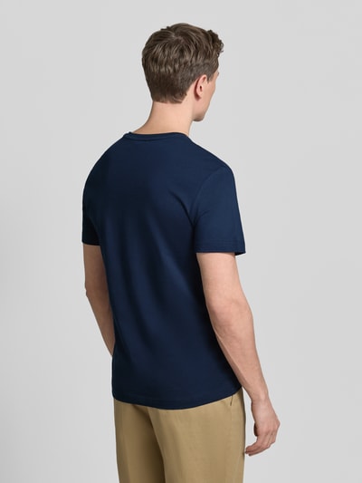 Männermodel trägt Regular Fit T-Shirt aus reiner Baumwolle von Lacoste, efekt: jednolity kolor, krój regular fit, wyhaftowane logo, dekolt w serek, krótki rękaw, bawełna, Ganzkörperansicht Rückansicht