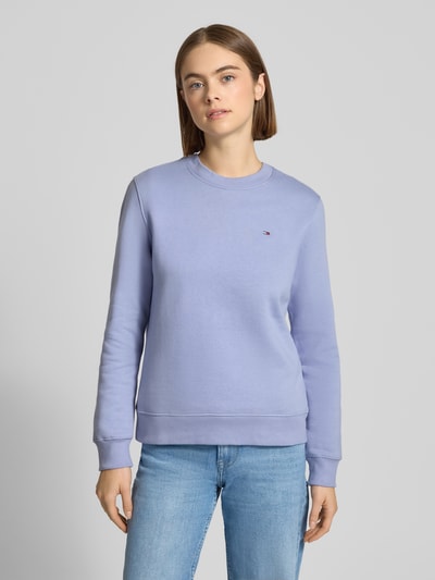 Kobiece modelka nosi Regular Fit Sweatshirt aus Baumwoll-Mix od Tommy Jeans, kolor jednolity, logo, długi rękaw, zdjęcie całej sylwetki z przodu.