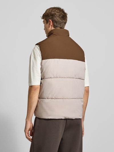 Männermodel trägt Weste mit Stehkragen Modell 'RAZE' von JACK & JONES in Braun und Beige, leicht wattiert, Ganzkörperansicht Rückansicht. Regular Fit, Label-Print, Reißverschluss, Eingrifftaschen, Rückenlänge 68 cm, Schulterbreite 41 cm, Brustweite 58 cm.