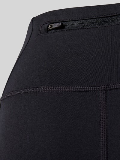 Produktfoto, Leggings mit Logo von Nike in Schwarz, glattes Material, sichtbare Nähte, Stretch-Anteil, elastischer Bund, Nahaufnahme. Damen Leggings von Nike Training, Material-Mix mit Stretch-Anteil, Körpernahe Passform, Logo, Elastischer Bund.