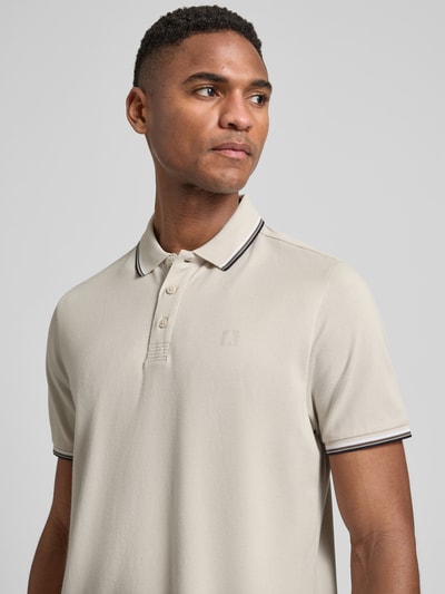 Męski model nosi Modern Fit Poloshirt mit Logo-Print Modell 'Keep Dry' od RAGMAN, mieszanka bawełny, kołnierzyk polo, listwa guzikowa, nadruk z logo, długość tyłu w rozmiarze M: 28 cm, jasny beż, gładka faktura, widok z przodu, zbliżenie na górną część ciała.