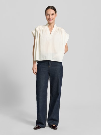 Vrouwenmodel draagt Relaxed Fit blouse met tuniekhals model 'Mirtilla' van Stefanel, puur katoen, met korte mouwen, ruglengte 58 cm, mouwlengte 10 cm, in crème en donkerblauw, geheel van voren.