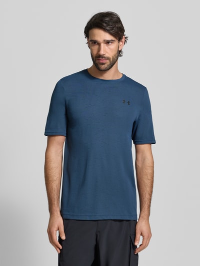 Mężczyznamodel nosi Slim Fit T-Shirt mit Logo-Print Modell 'Vanish' von Under Armour w kolorze granatowym, krój slim fit, z okrągłym dekoltem i lekką perforacją, szerokość w rozmiarze M: 40 cm, długość wewnętrzna rękawa w rozmiarze M: 70 cm, widok na całe ciało z przodu.