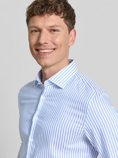 Männermodel trägt Slim Fit Business-Hemd aus Baumwolle mit Kentkragen von SEIDENSTICKER, gestreifter Allover-Look, Nahaufnahme Oberkörper.