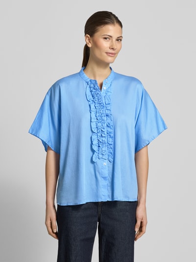 Frauenmodel trägt Relaxed Fit Bluse mit Rüschen Modell 'DAISY' von 0039 Italy in Hellblau, reine Baumwolle, Ganzkörperansicht von vorne.