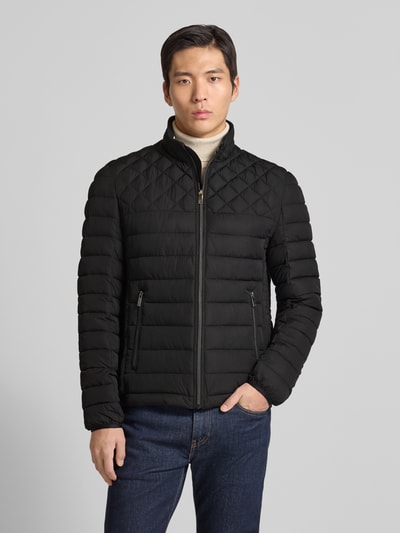 Męski model nosi Slim Fit Steppjacke mit gefüttertem Kragen von Christian Berg Men, czarna kurtka pikowana, kieszenie zapinane na zamek błyskawiczny, elastyczne zakończenia rękawów, krój slim fit, długość tyłu w rozmiarze M: 68 cm, szerokość ramion w rozmiarze M: 47 cm, szerokość w rozmiarze M: 52 cm, długość rękawów w rozmiarze M: 68 cm, widok na cały korpus z przodu