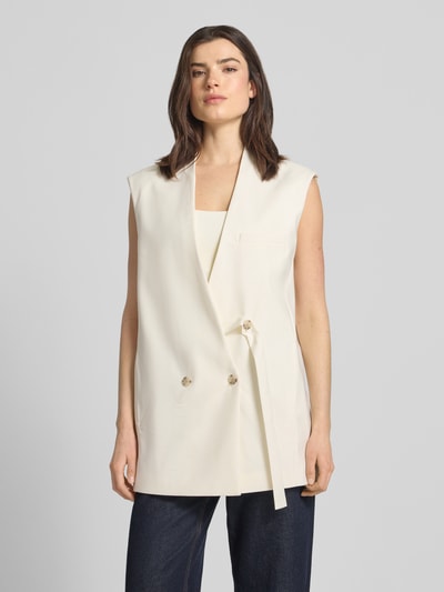 Frauenmodel trägt Oversized Anzugweste aus Schurwoll-Mix Modell 'JAWIKIRI' von BOSS, Optik: Unifarben, Passform: Oversized, V-Ausschnitt, doppelte Knopfleiste mit Riemen-Details, Brustleistentasche und seitliche Eingrifftaschen, Material: Schurwoll-Mix, Cremefarbe, glatte Textur, Ganzkörperansicht von vorne.