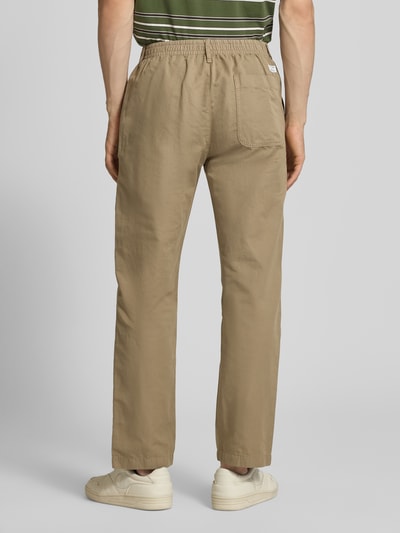 Męski model nosi Relaxed Fit Chino aus Baumwolle-Leinen-Mix Modell 'FILIP RELAXED' von Marc O'Polo Denim, efekt: jednolity kolor, krój relaxed fit, naszywka z logo, szlufki na pasek, zapięcie na guzik i zamek błyskawiczny, elastyczny pas, mieszanka bawełny i lnu, całkowity widok z tyłu.