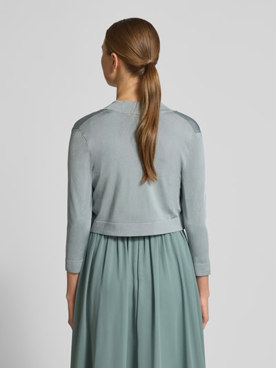 Młodzieżowy modelka nosi Bolero mit Schalkragen od Jake*s Cocktail, błyszczący materiał w niebieskim odcieniu, widok całej sylwetki z tyłu.