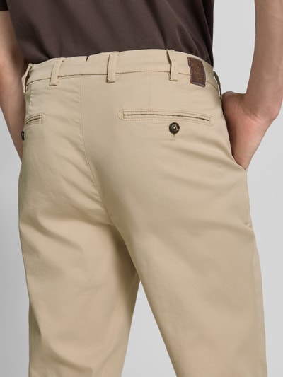 Männermodel trägt Slim Fit Hose mit Eingrifftaschen Modell 'Tybalt 5' von g1920, beige, Baumwoll-Mix, Soft Touch, Ganzkörperansicht Rückansicht.
