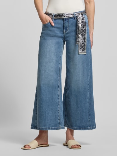 Frauenmodel trägt Wide Fit Jeans mit Viskose-Anteil Modell 'Palazzo' von Buena Vista, Paisley-Stoffband, mittleres Blau, Nahaufnahme Oberkörper bis Fuß, Kontext: elastischer Baumwoll-Mix, verkürzte Passform, 5-Pocket-Design, Knopf- und Reißverschluss.