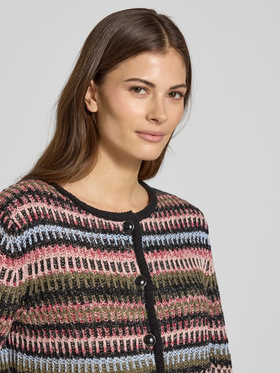 Frauenmodel trägt Strickjacke mit Rundhalsausschnitt von Oui aus Baumwoll-Mix mit Viskose-Anteil, Knopfleiste, Ziertaschen, Nahaufnahme Oberkörper.