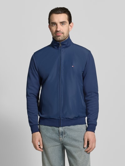 Mannenmodel draagt Regular Fit Blouson uit katoenmix van Tommy Hilfiger, effen kleur, opstaande kraag, lange mouw, steekzakken, gestikt logo, rompzoom en mouwboord elastisch, sluiting met ritssluiting, geheel van voren te zien