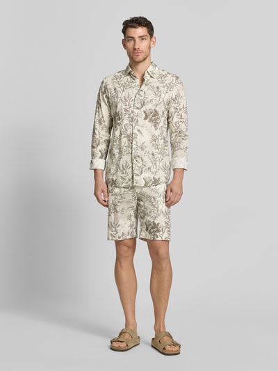 Männermodel trägt Shorts aus Leinen-Mix mit Eingrifftaschen von MCNEAL, helle Farben mit floralem Muster, gerader Schnitt, Ganzkörperansicht von vorne.