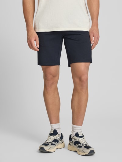 Männermodel trägt Regular Fit Chinoshorts aus Viskose-Mix Modell 'MARK' von Only & Sons in Melange-Optik, Eingrifftaschen, Ganzkörperansicht von vorne.