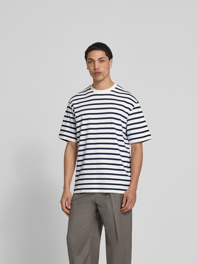 Männermodel trägt T-Shirt mit Rundhalsausschnitt von Filippa K, Relaxed-Fit, Reine Baumwolle, kurzärmelig, Rückenlänge 76 cm, Ganzkörperansicht von vorne.