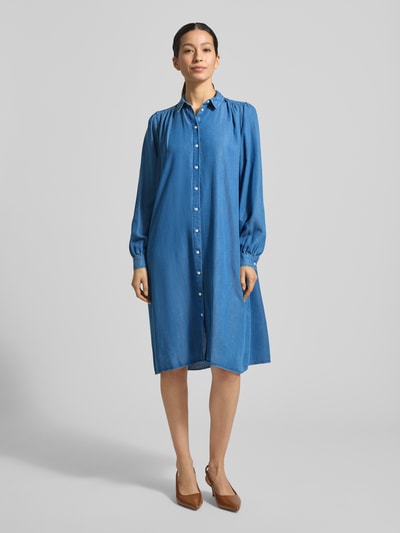 Modelka nosi Knielanges Hemdblusenkleid in Denim-Optik od Smith & Soul z czystego lyocellu, prosty krój, długość do kolan, kołnierzyk koszulowy, listwa guzikowa, długość tyłu w rozmiarze S: 104 cm, szerokość w rozmiarze S: 49 cm, długość rękawów w rozmiarze S: 65 cm, tkanina stylizowana na denim, widok całej sylwetki od przodu.