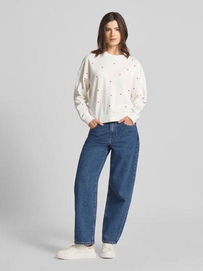 Frauenmodel trägt Regular Fit Sweatshirt aus reiner Baumwolle von Tom Tailor Denim in Unifarbe mit Allover-Stickerei, Crew Neck, lange Ärmel, gerippte Abschlüsse, Sweat-Textur, Ganzkörperansicht von vorne.