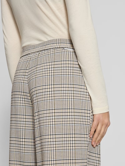 Frauenmodel trägt Weite Hose mit Viskose-Anteil von Marc O'Polo Denim, Optik: Unifarben, kariert, Label-Stitching, Bundfalte, elastischer Bund, seitliche Eingrifftaschen, Materialverarbeitung: Webware, Nahaufnahme Rückansicht.