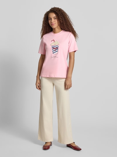 Frauenmodel trägt Regular Fit T-Shirt aus reiner Bio-Baumwolle Modell 'BURST' von Only in Rosa, Optik: Unifarben, mit Perlen- und Paillettenbesatz, Rundhals, Kurzarm, Materialverarbeitung: Jersey, Ganzkörperansicht von vorne.