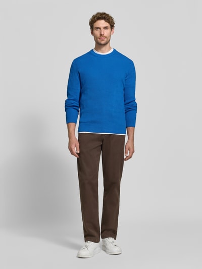 Męski model nosi Regular Fit Strickpullover aus Baumwoll-Mix od MCNEAL, kolor niebieski, okrągły dekolt, elastyczne wykończenia, długość tyłu 65 cm, długość rękawów 56 cm, Ganzkörperansicht von vorne.