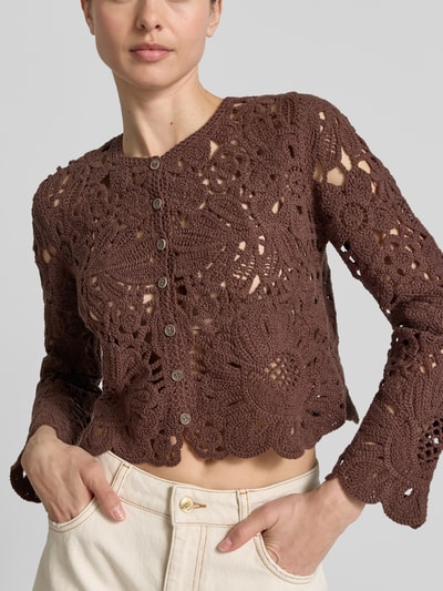 Frauenmodel trägt Cardigan aus Häkelspitze mit Rundhalsausschnitt von Jake*s Collection aus Reiner Baumwolle, Gerader-Schnitt, Knopfleiste, braune Farbe, florale Struktur, Nahaufnahme Oberkörper.