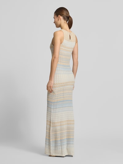 Frauenmodel trägt Strickkleid aus Viskose-Mix Modell 'ROSALYN' von Guess, Maxi, eng anliegend, helle Pastellfarben, Ganzkörperansicht Rückansicht.