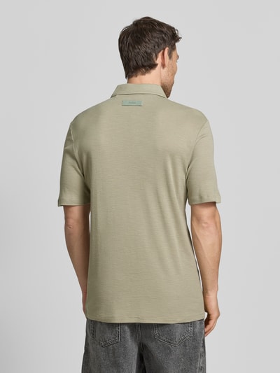 Männermodel trägt Slim Fit Poloshirt aus Lyocell-Leinen-Mix Modell 'DULIN' von HUGO, Optik: Unifarben, Label-Applikation, Ganzkörperansicht Rückansicht.