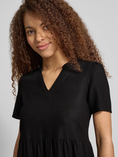 Vrouwenmodel draagt A-lijn vrijetijdsjurk model 'TIRI-GOA' van Only, look: effen, minilengte, V-hals, korte mouw, mix van viscose en linnen, gevlamd garen, nahaufnahme bovenlichaam.