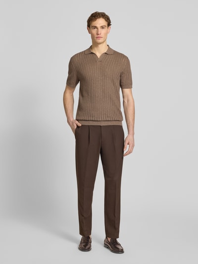 Männermodel trägt Slim Fit Poloshirt aus Baumwoll-Leinen-Mix von Profuomo in Braun, V-Ausschnitt, Kurzarm, Ganzkörperansicht von vorne.