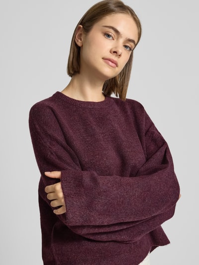 Frauenmodel trägt Relaxed Fit Pullover mit Rundhalsausschnitt Modell 'SIMONI' von ONLY in Dunkelrot, weiche Textur, Damen Pullover, Nahaufnahme Oberkörper.