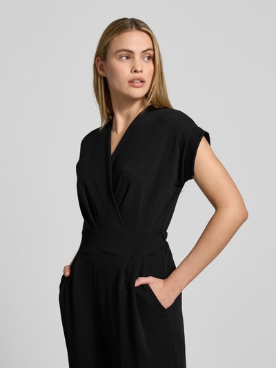 Frauenmodel trägt Jumpsuit mit Eingrifftaschen Modell 'Ko44a' von ZABAIONE aus schwarzem Material-Mix mit Stretch-Anteil, Nahaufnahme Oberkörper