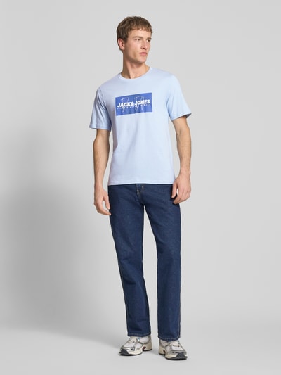 Männermodel trägt Regular Fit T-Shirt aus reiner Baumwolle Modell 'COLE' von Jack & Jones mit Label-Print, Rundhalsausschnitt, Ganzkörperansicht von vorne.