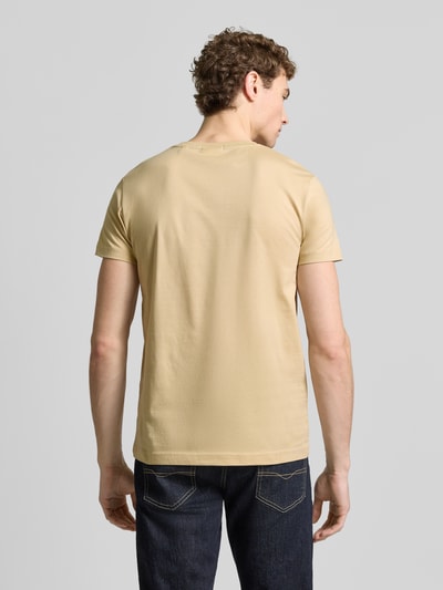 Männermodel trägt T-Shirt mit Label-Detail von Gant in Beige, reine Baumwolle, gerader Schnitt, Rückenlänge 70 cm, Ganzkörperansicht Rückansicht.