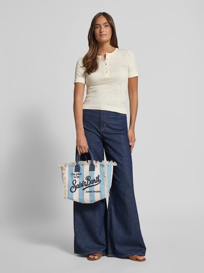 Vrouwenmodel draagt Handtasche mit Label-Print und Fransen Modell 'COLETTE' van MC2 Saint Barth van puur katoen, labelprint, franjes, hoofdvak met ritssluiting, draagband, schouderbandlengte 117 cm, breedte 28 cm, lengte 23 cm, diepte 14 cm, voorkant geheel in beeld