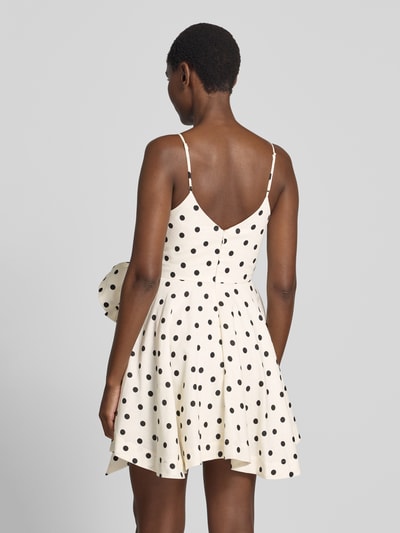 Frauenmodel trägt Cocktailkleid in Wickel-Optik von Forever New, weiß mit schwarzen Punkten, reine Baumwolle, taillierte Passform, Rückenansicht.