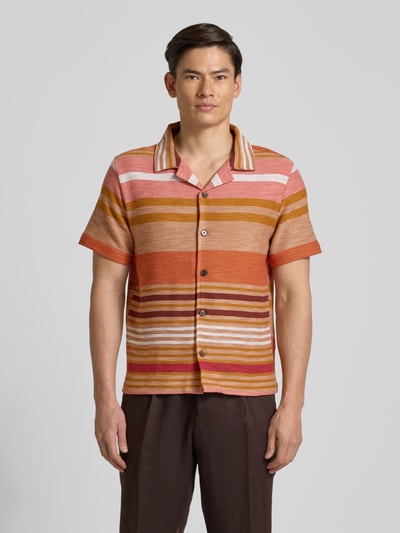 Männermodel trägt Slim Fit Freizeithemd mit Reverskragen Modell 'Carlo' von Zuitable, gestreift in Orange-, Braun- und Pinktönen, Ganzkörperansicht von vorne, Baumwoll-Mix mit Viskose-Anteil, Allover-Look, kurze Ärmel.