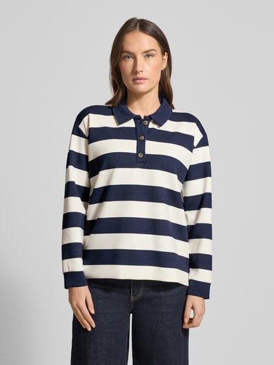 Frauenmodel trägt Sweatshirt mit Polokragen und Knopfleiste von Christian Berg Woman im Material-Mix mit Modal-Anteil, Regular-Fit, Querstreifen in Dunkelblau und Creme, glatte Textur, Ganzkörperansicht von vorne.